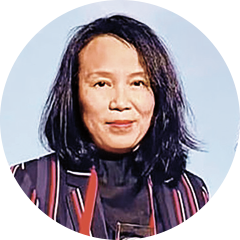 Circular headshot of a woman wearing a patterned scarf and dark jacket against a light background.