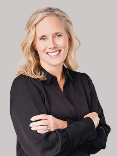 profile of smiling woman with blond hair, arms crossed, in a black dress shirt