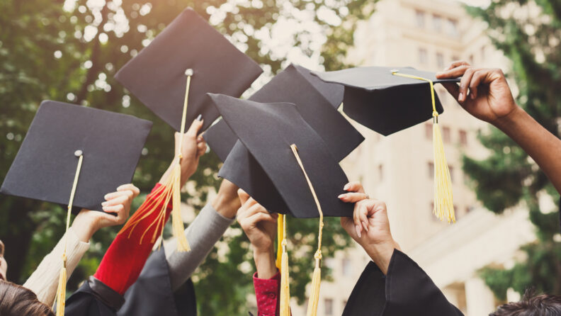 Graduation caps raised in the air.