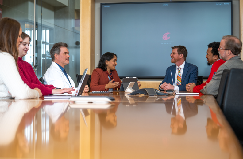 Photo of physicians and administrators at a conference table.