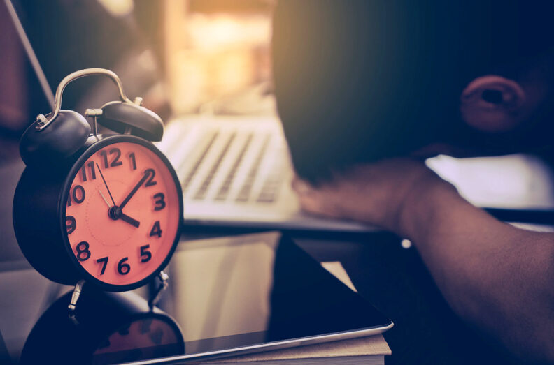 alarm clock person at computer