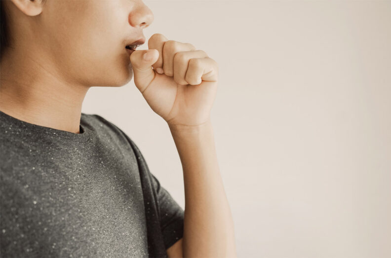 Close up of teen boy coughing from cold and flu,COPD, pneumonia, bronchitis, asthma, allergy, respiratory illness concept