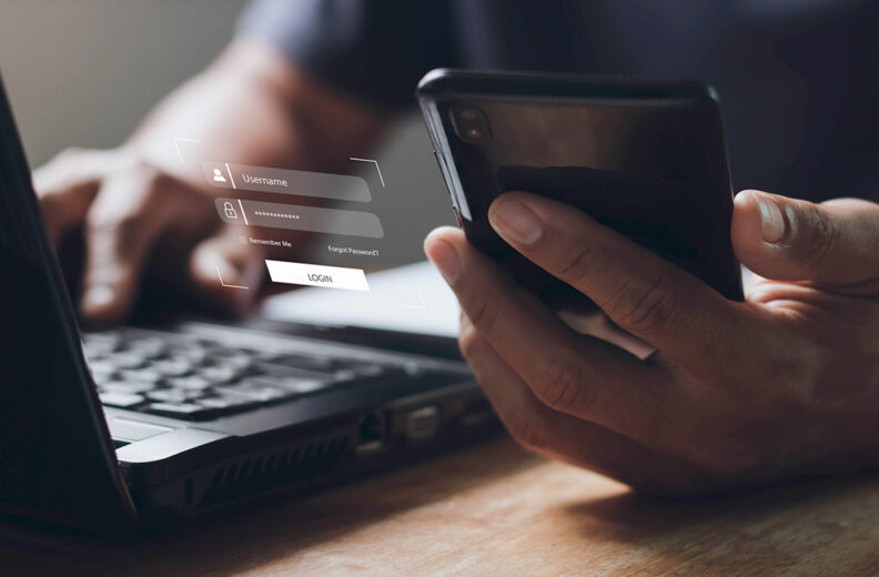 Person using a smartphone and laptop.