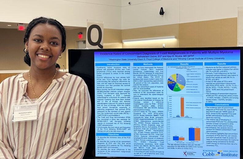Bethelehem Gebre, MD Student standing next to presentation board