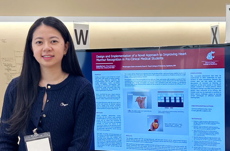 MD Student standing next to presentation board