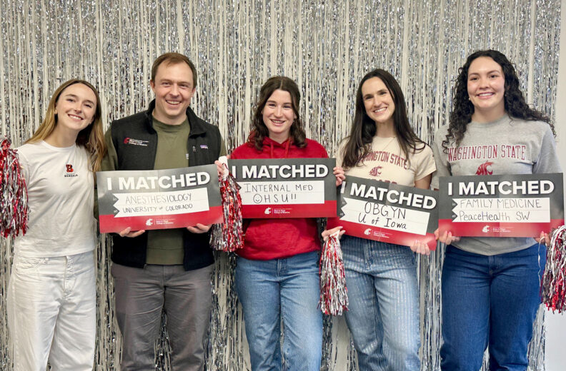 Group of MD students holding their match day signs.
