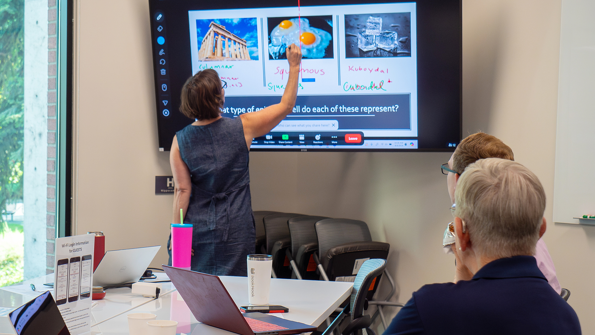 Faculty member marking up presentation screen during retreat.