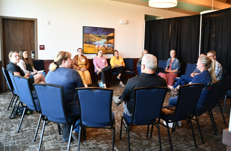 A group of people sitting in a circle, having a discussion.