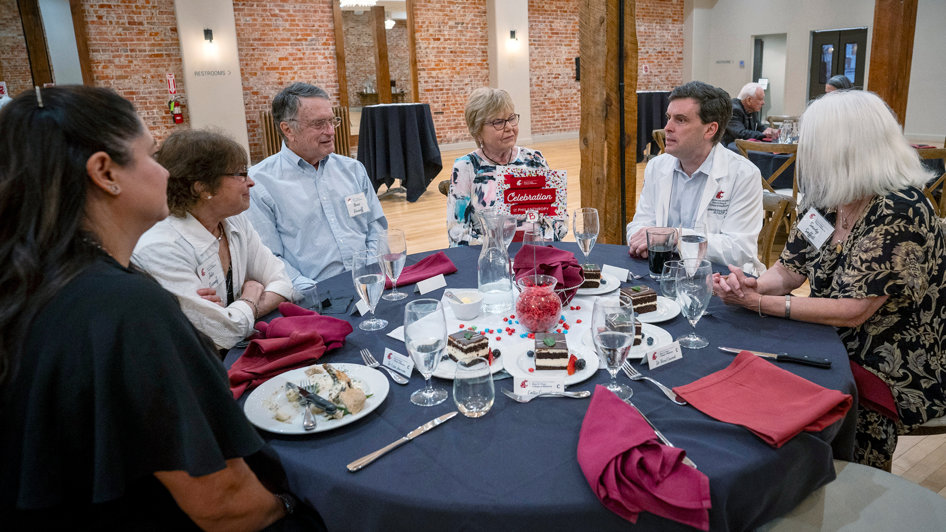 Dean and faculty with donors setting around a table talking.