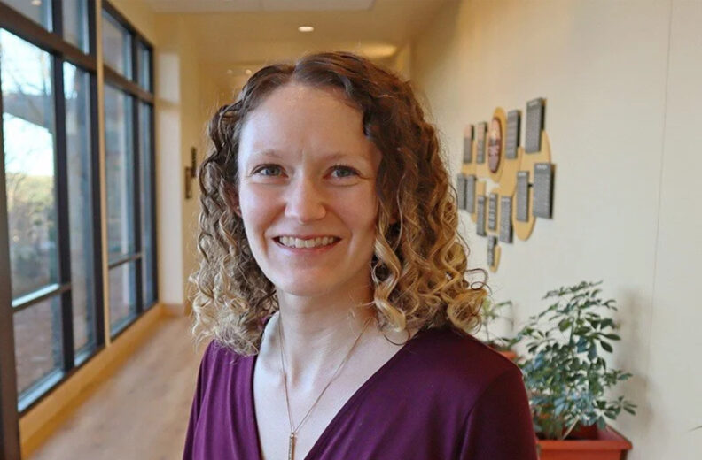 A women smiling in a hallway.