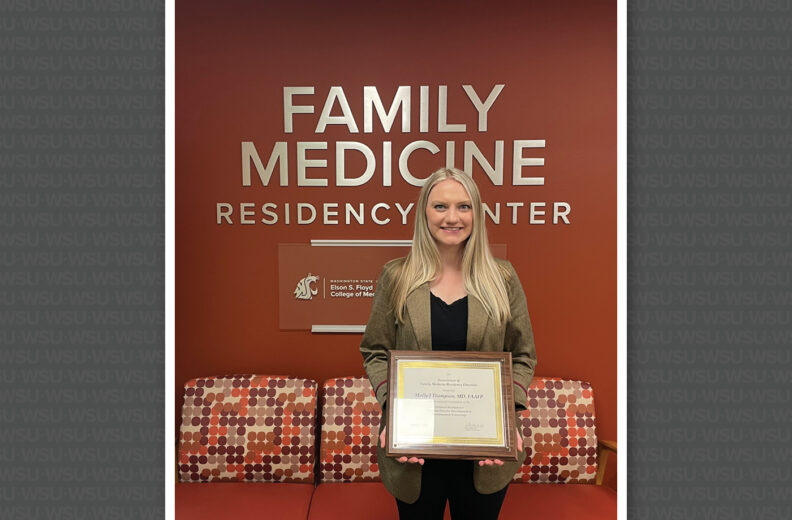 Molly Thompson holding an award.