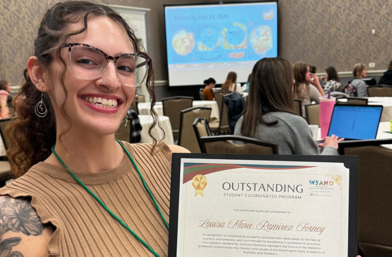 A person holds an ‘Outstanding Student Coordinated Program’ certificate at a conference.