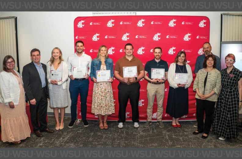 Six MD students holding their awards in a group photo along side the Dean and faculty and staff members.