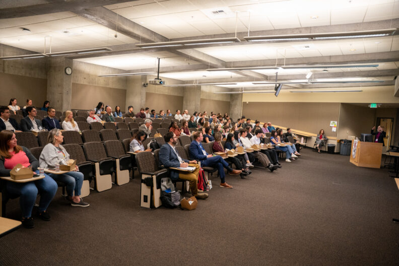 People listening to a speaker in an auditorium. 