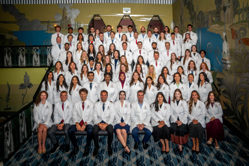 A class photo with eighty students and the dean. 