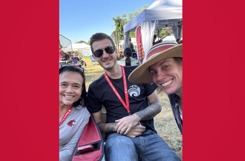 Three people smiling for a selfie outside.