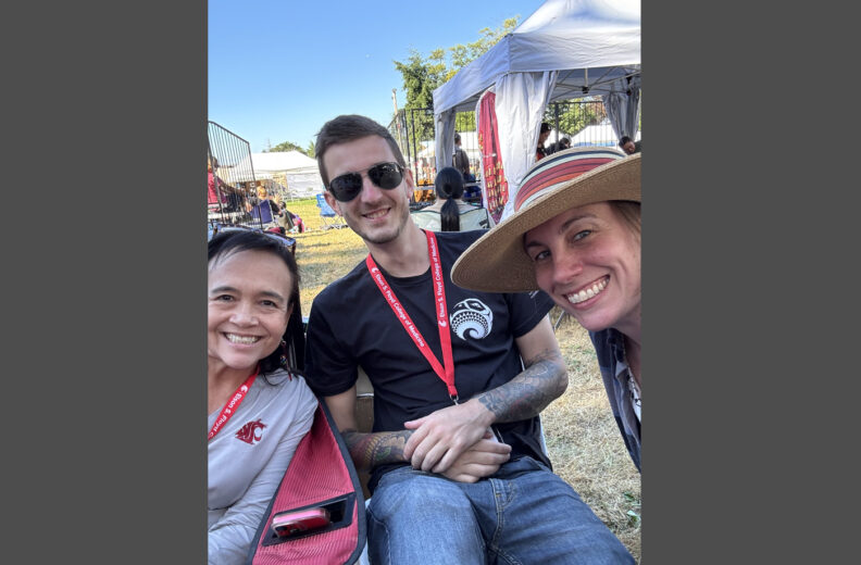 Three people smiling for a selfie outside.