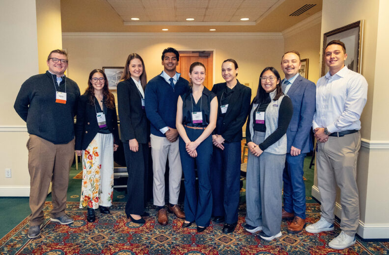 Nine young professionals smiling for a photo.