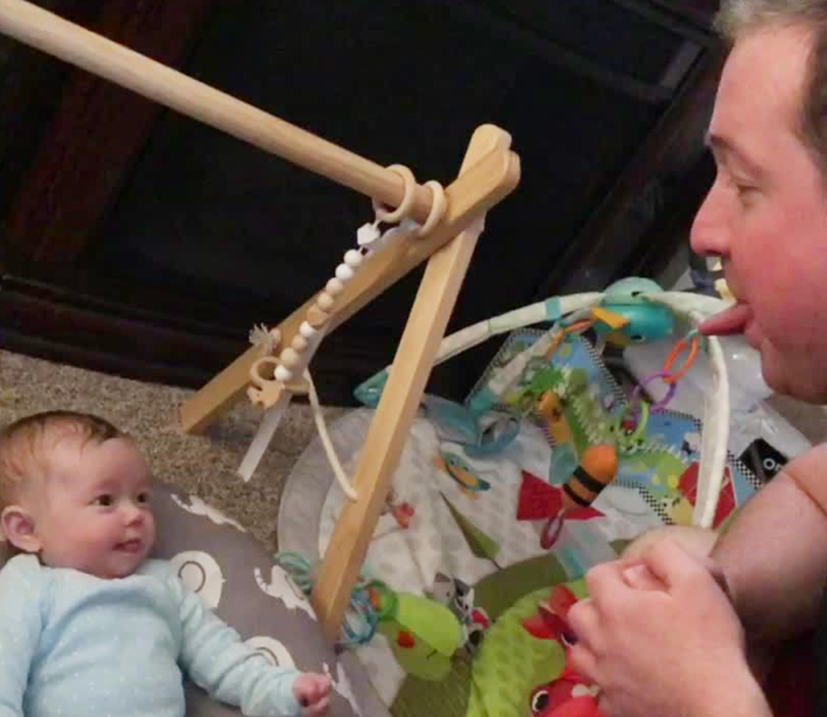 Adult and baby sticking out their tongues