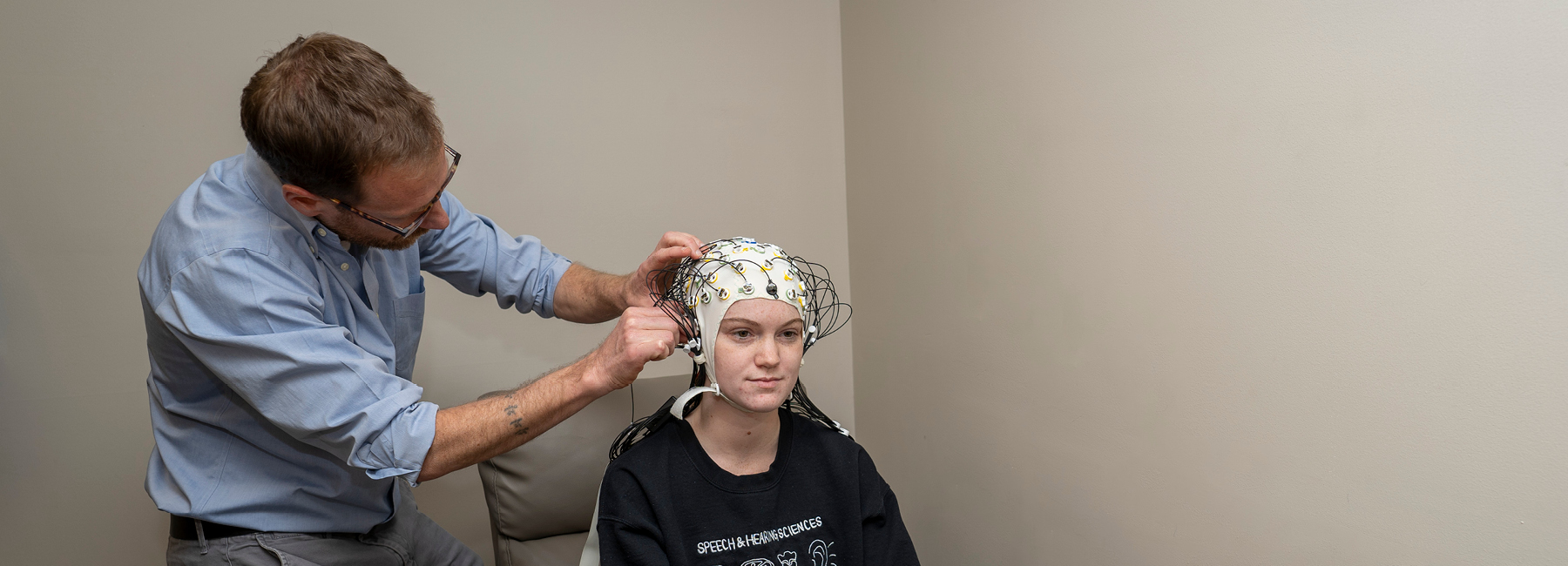 Researcher prepping patient for Speech Electrophysiology test.