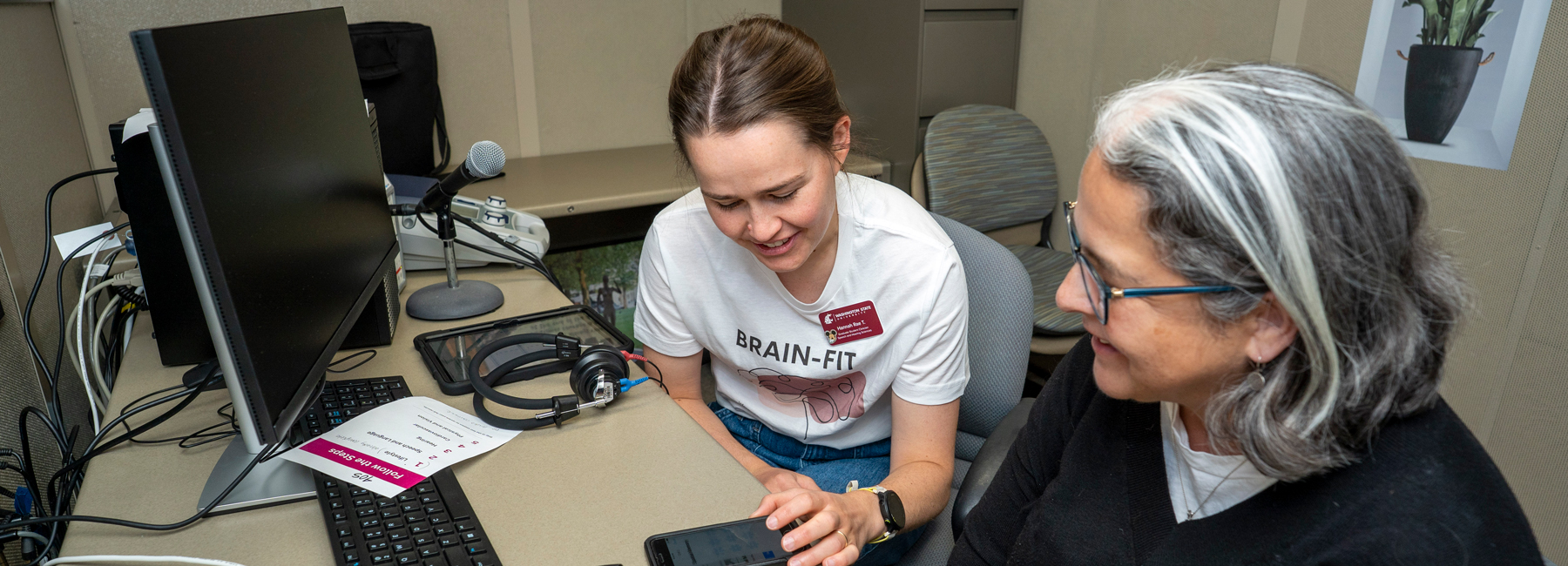 Graduate student giving a brain fit screening using their phone.
