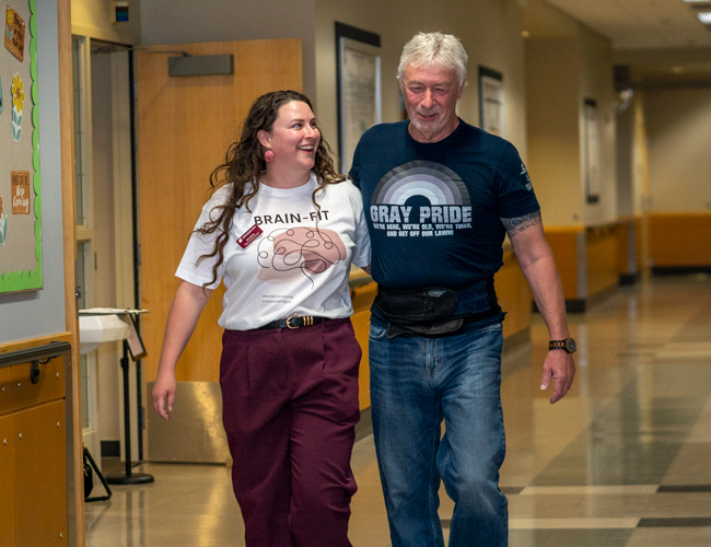 Researcher walking patient down the hallway in the clinic.