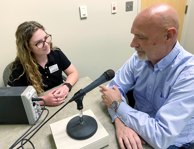 SHS student working with a patient preforming a speech test.