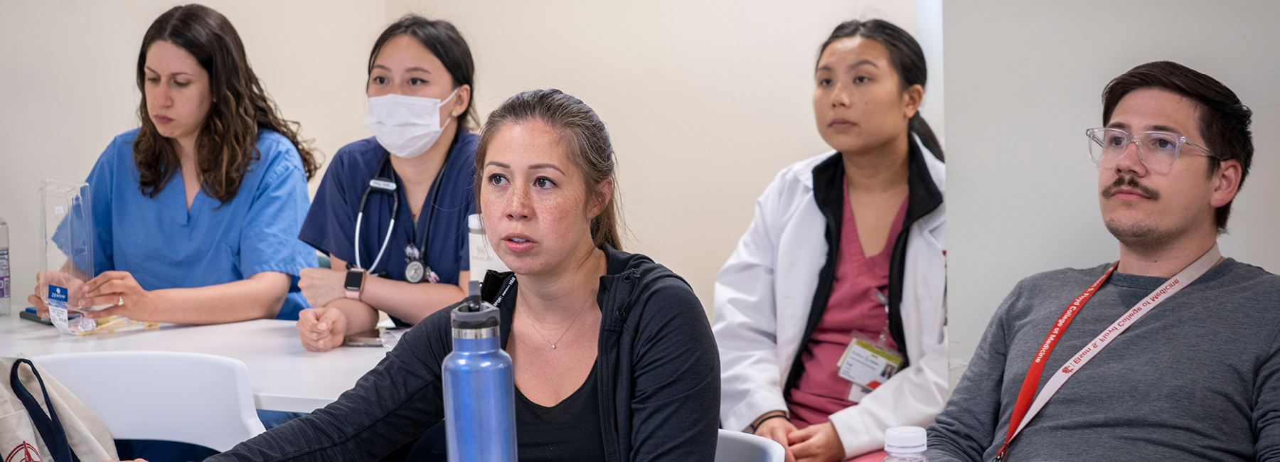 Group of five residents in a training session listening to a speaker.