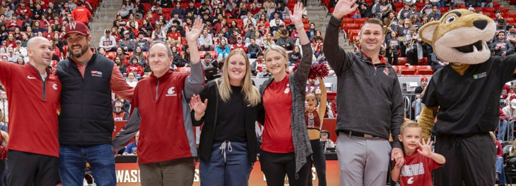 Residents and doctors at the WSU basketball game waving to the crowd.