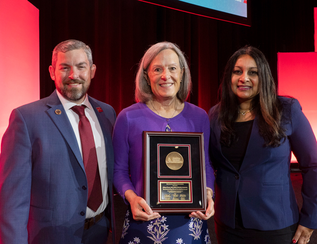Alison Evert holding an award from the American Diabetes Association, standing with two other people.