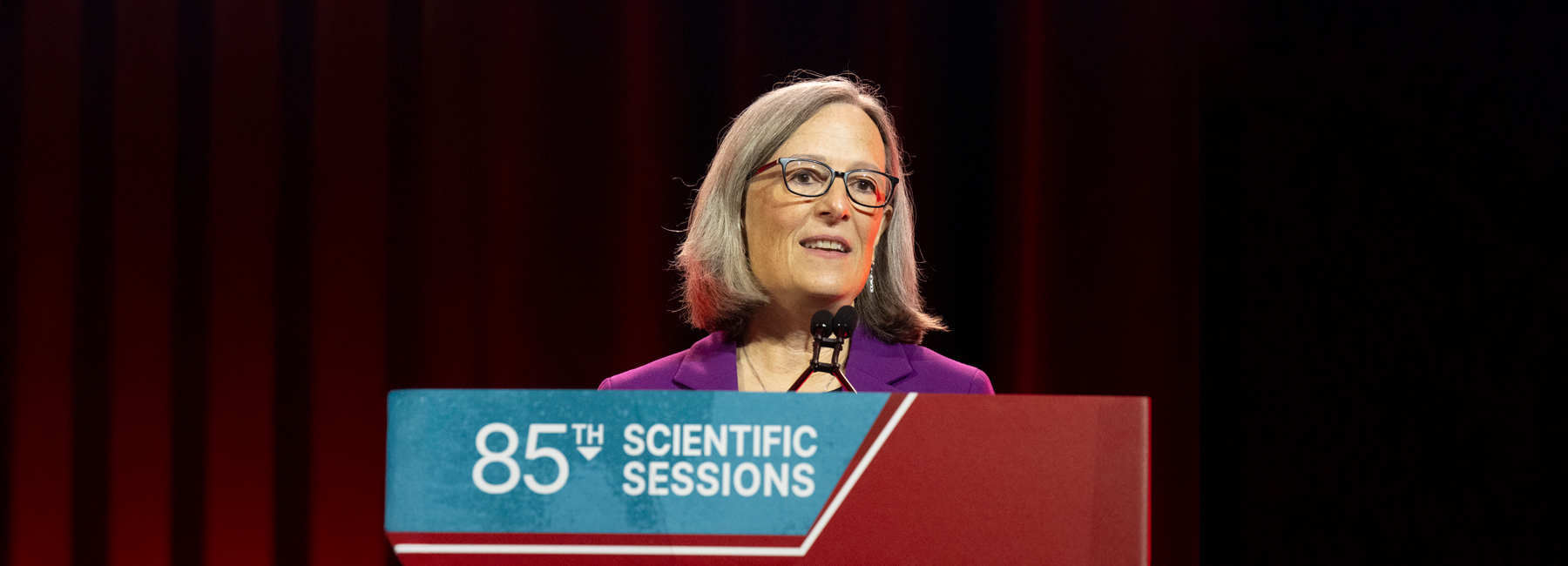 Alison Evert speaking at a podium.