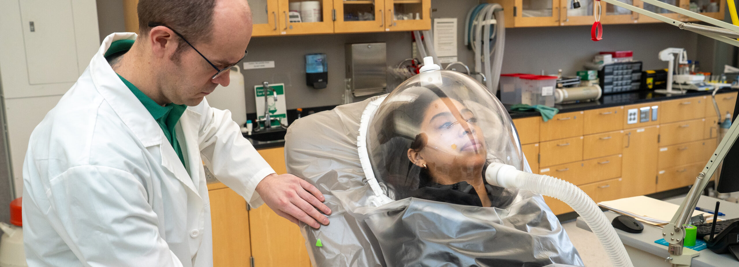 Researcher Patrick Solverson fitting a testing device on participant Sarai Rios for an Elderberry research study.