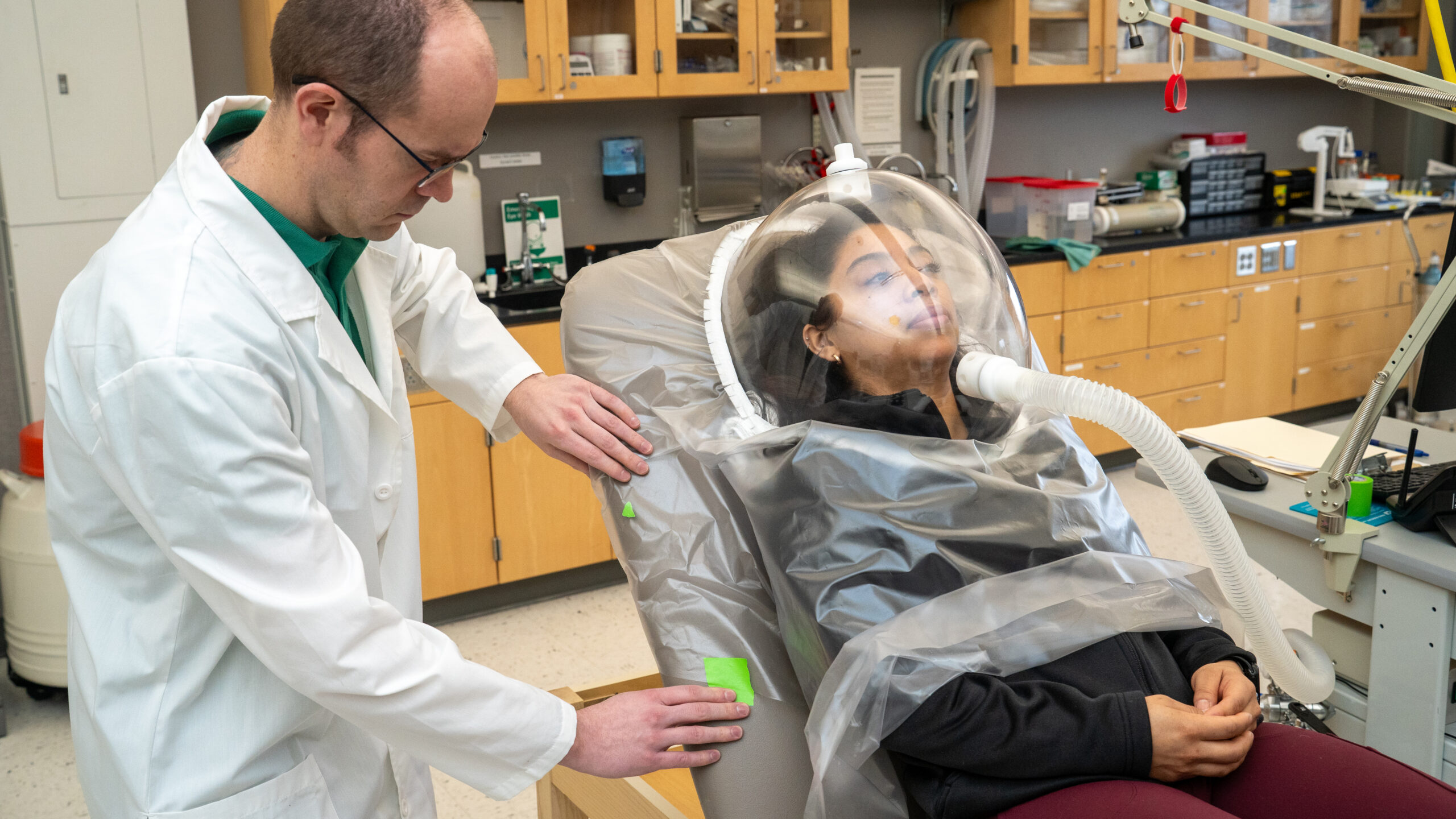 Researcher Patrick Solverson fitting a testing device on participant Sarai Rios for an Elderberry research study.