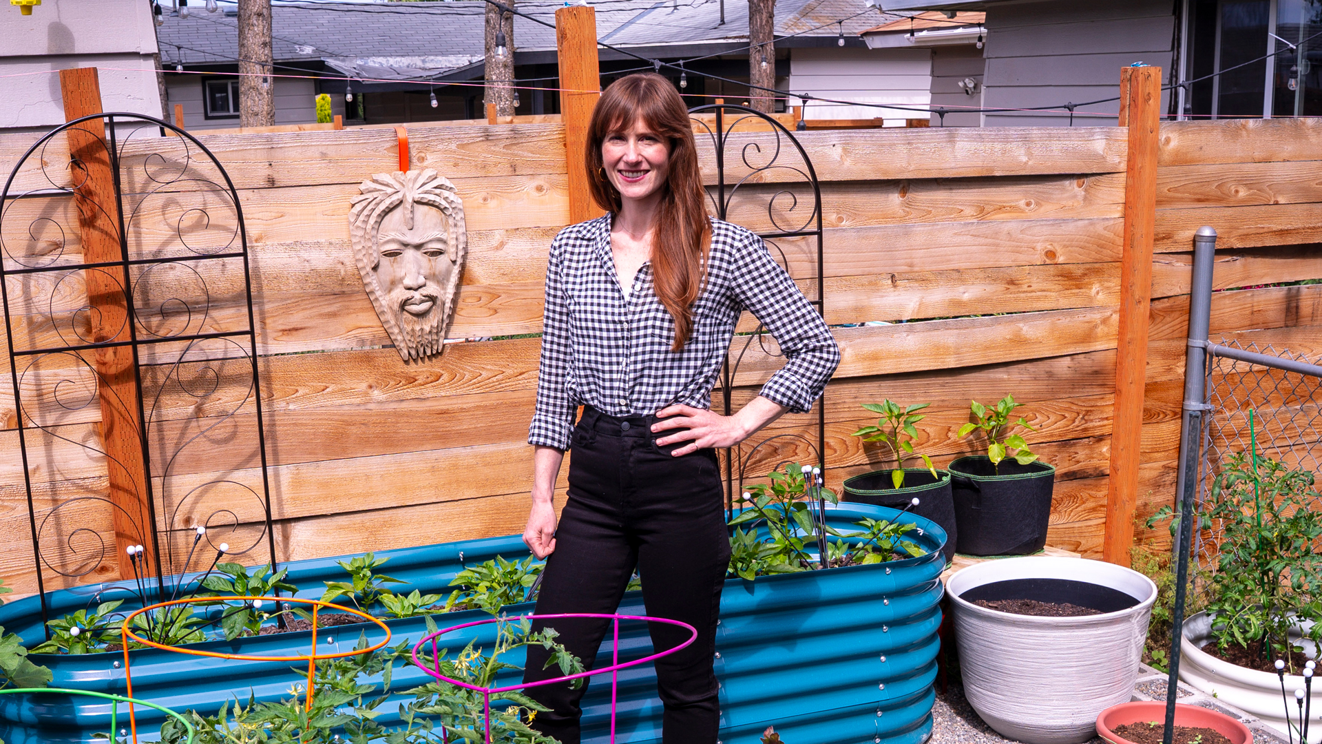 Martine Perrigue standing in a garden with raised garden beds.