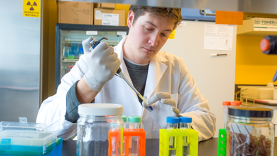 Researcher putting liquid in a tube