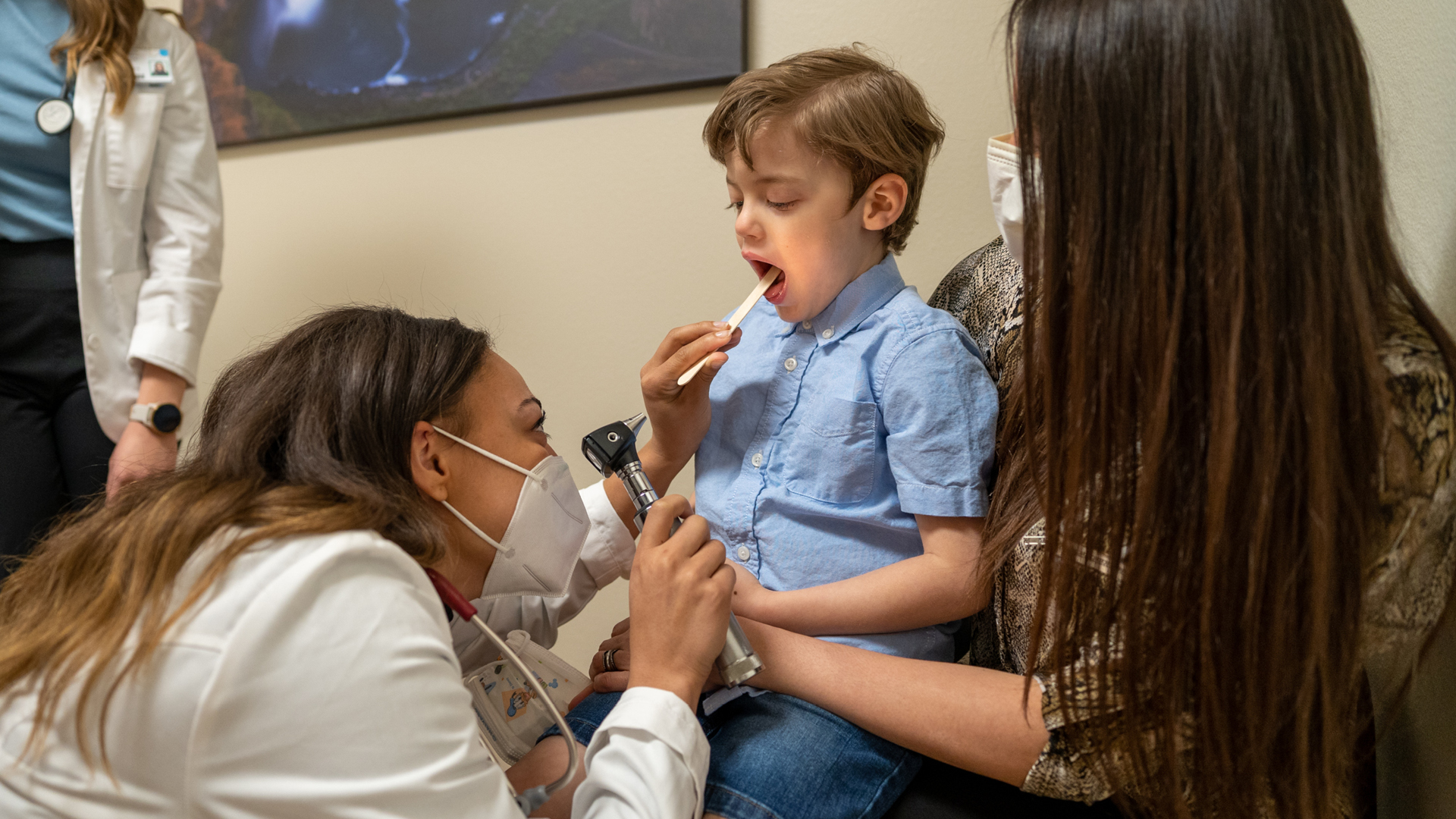 Parent holding child during doctor exam