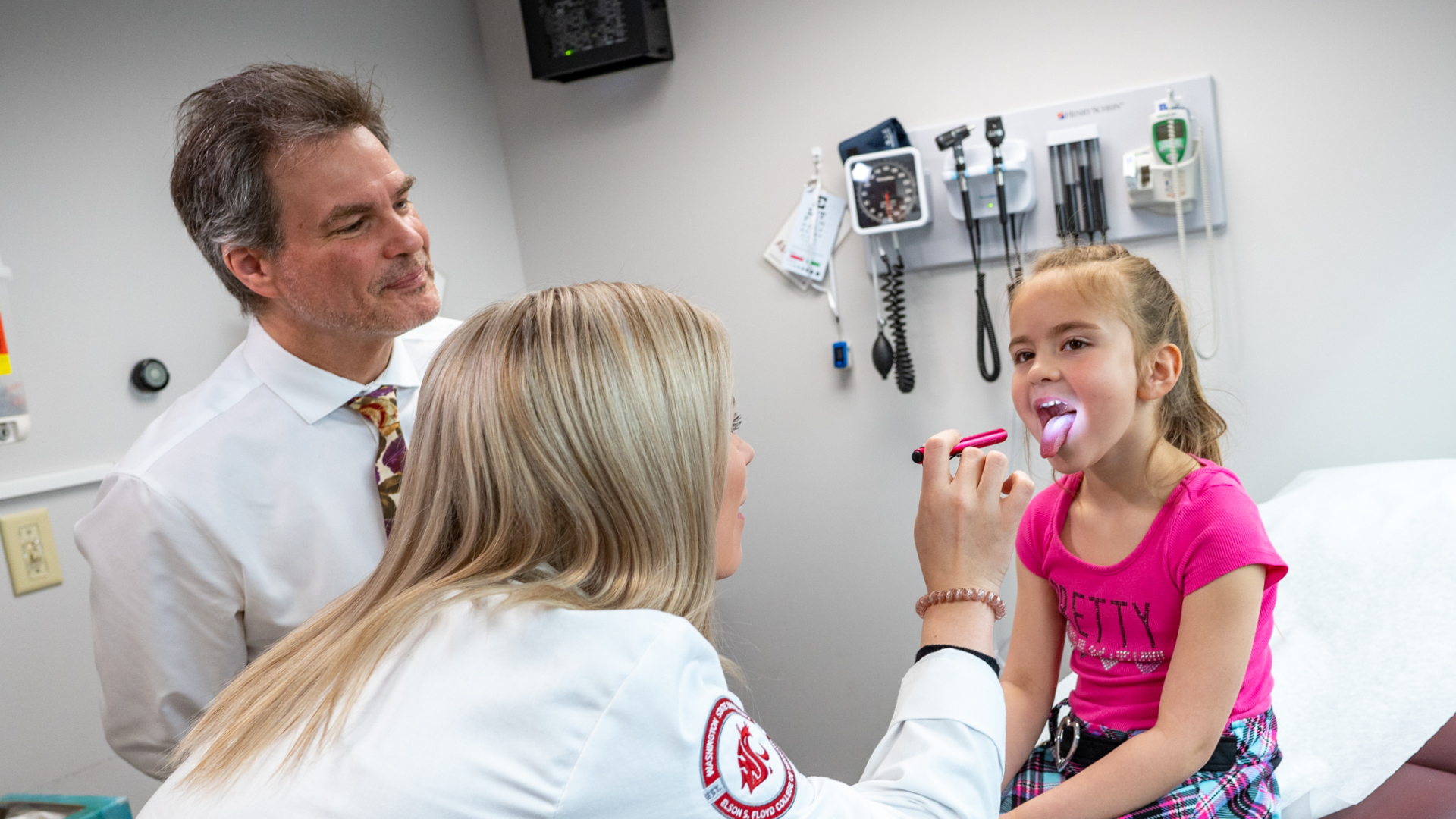 Dr Anderson with with student and child in exam room