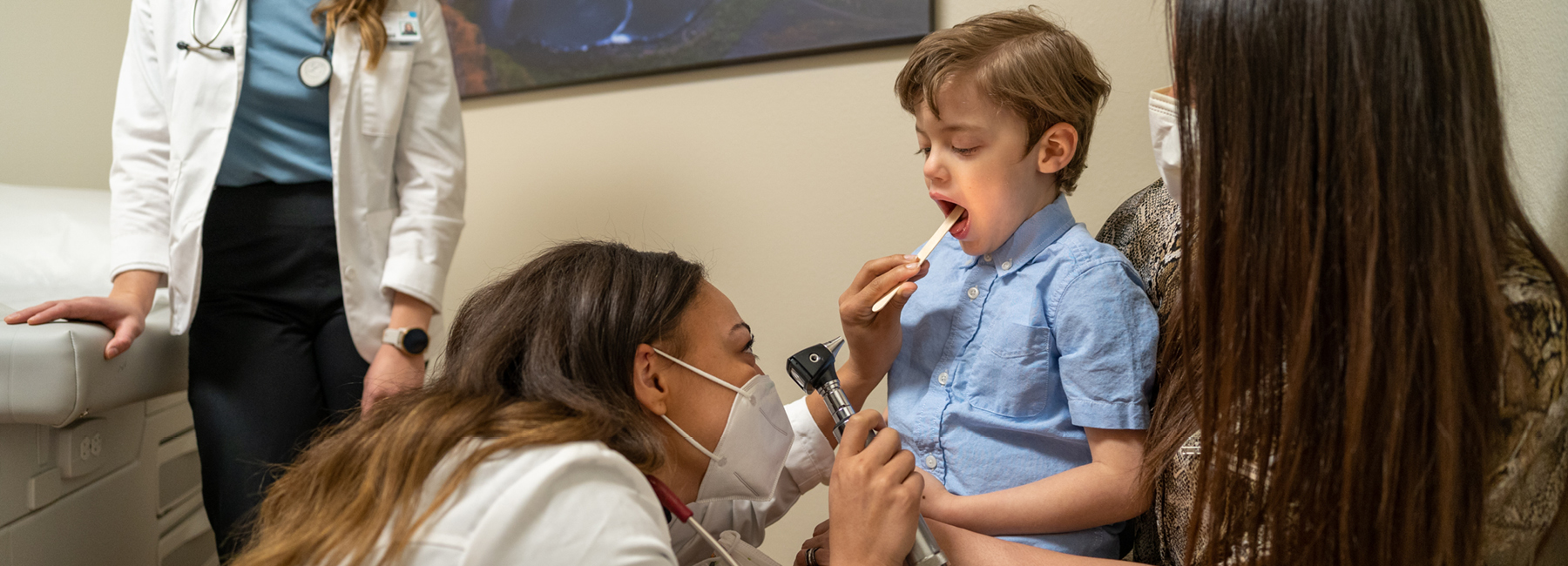 Parent holding child during doctor exam