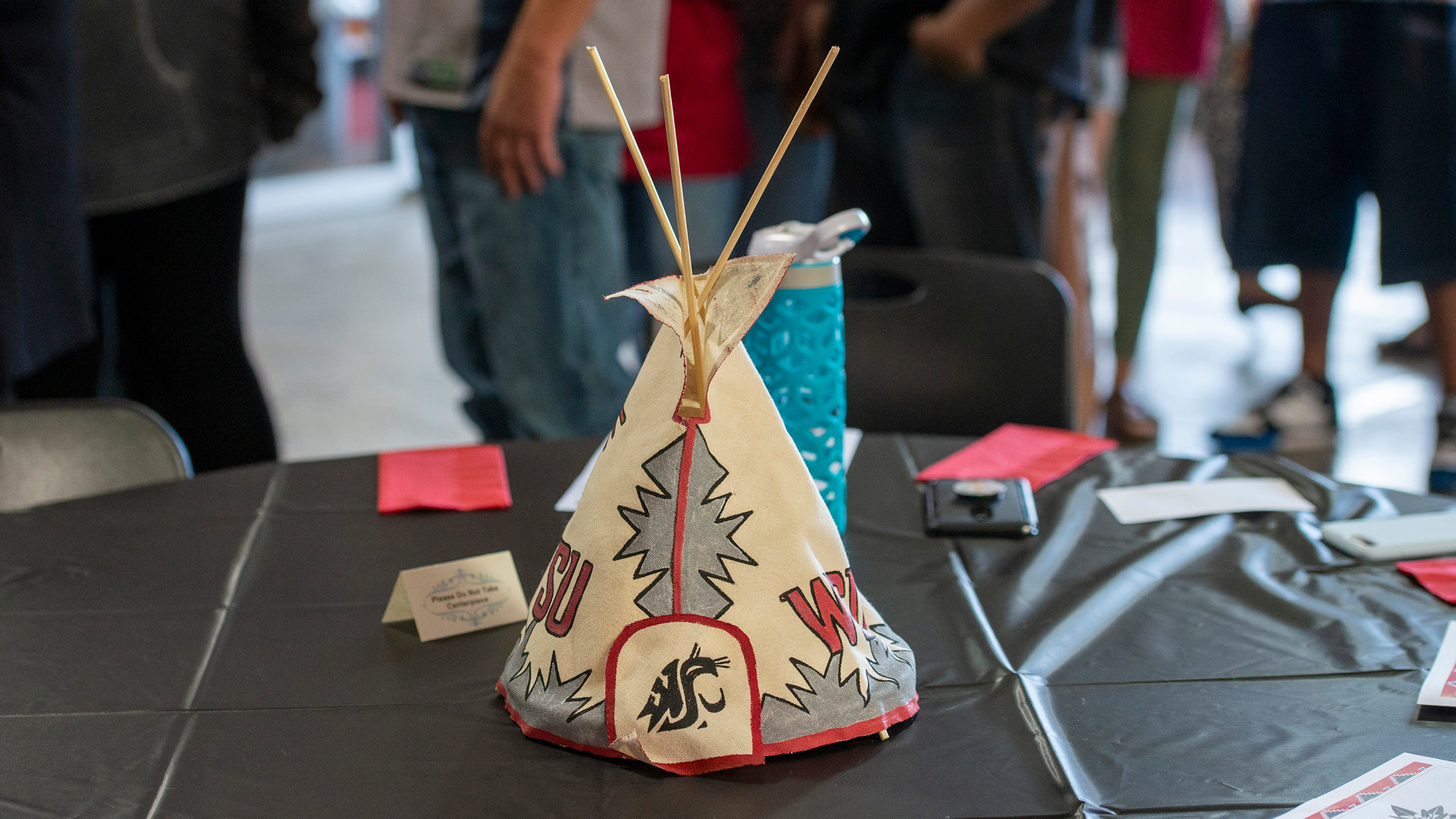 A WSU-themed tipi serves as a centerpiece at an empty table.