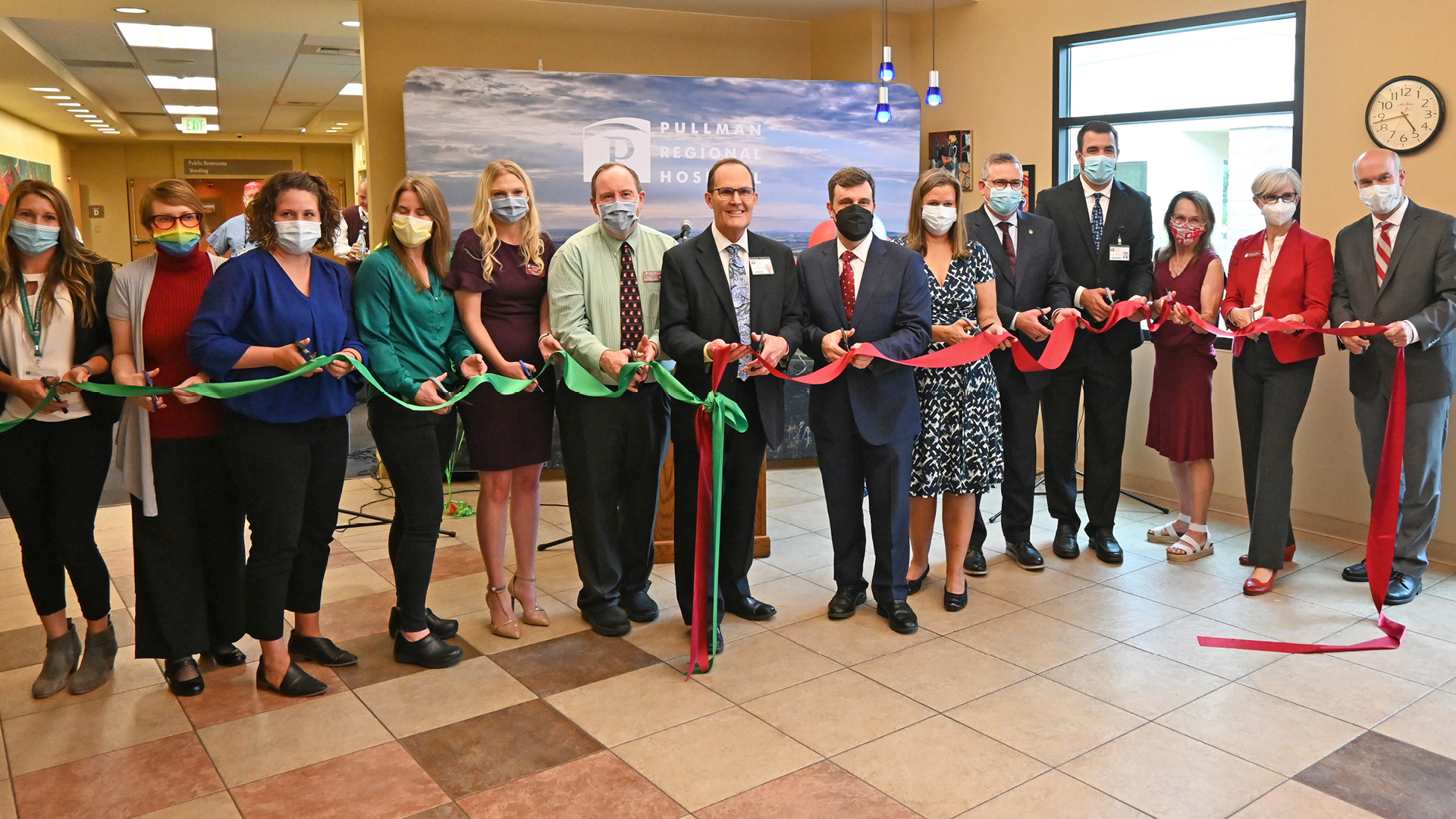 Group of people cutting a ribbon to make the open of the Family Medicine Residency Center opens. 