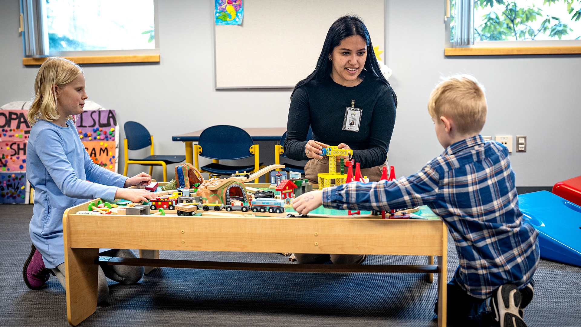 Graduate student working with two children at the Autism Clinic.