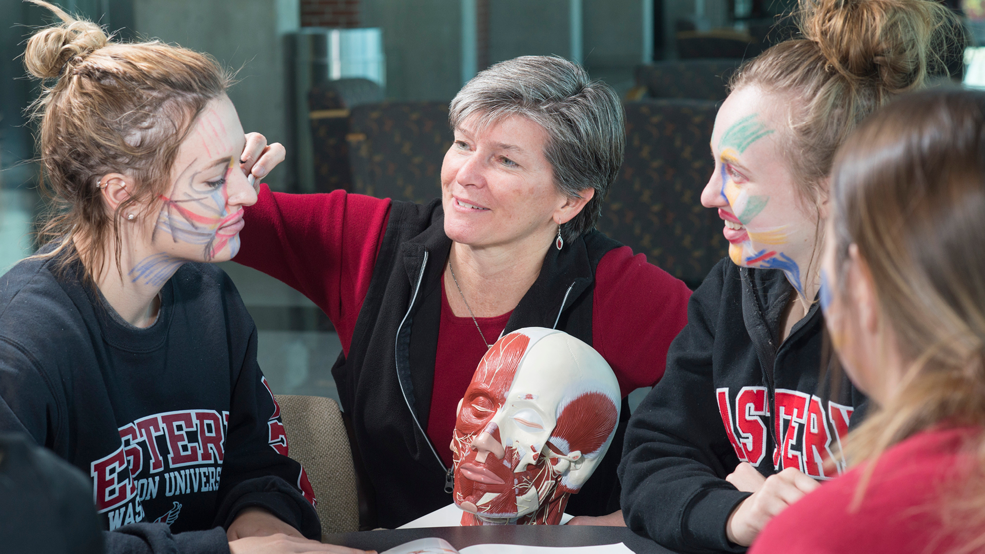 Professor drawing on a speech and hearing students face.