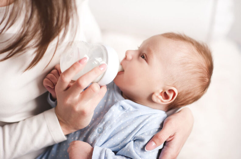 Mother feeding baby with a bottle.