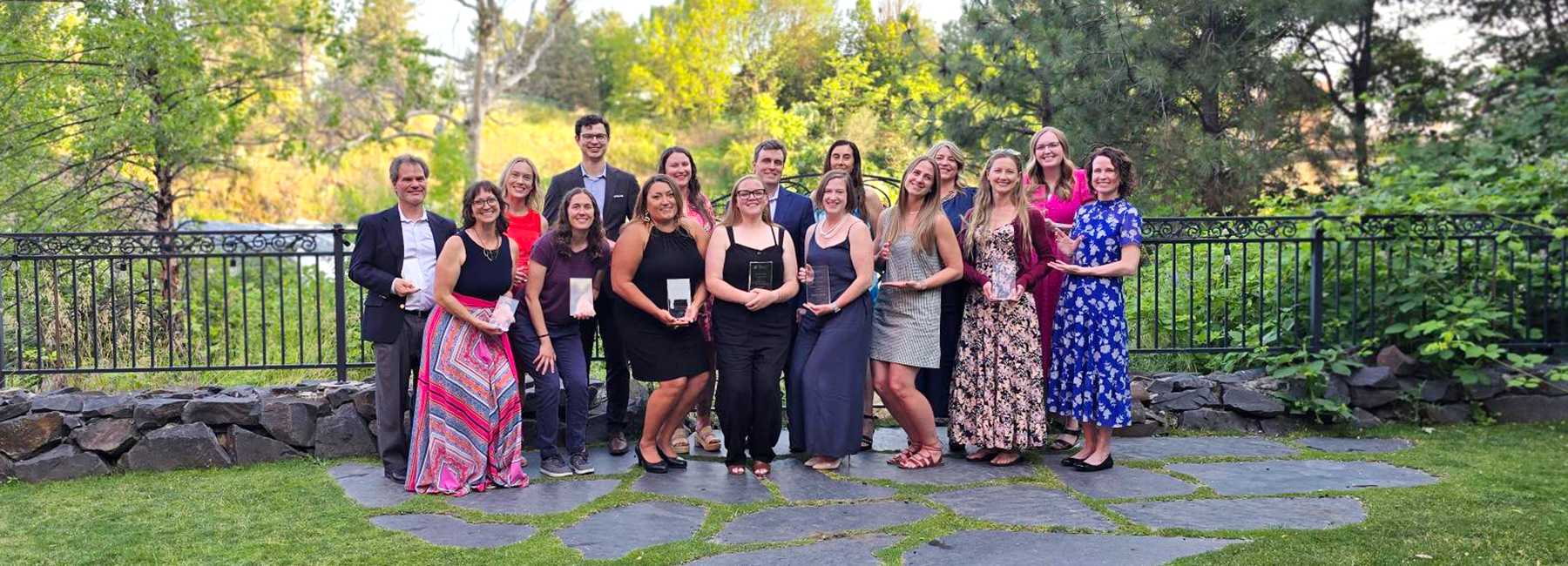 Group of faculty and staff holding their awards outside.