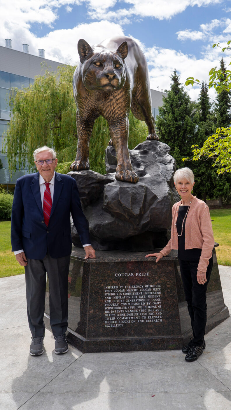 Dr Joel and Janet DeLisa standing next to cougar statute on the WSU Spokane campus.