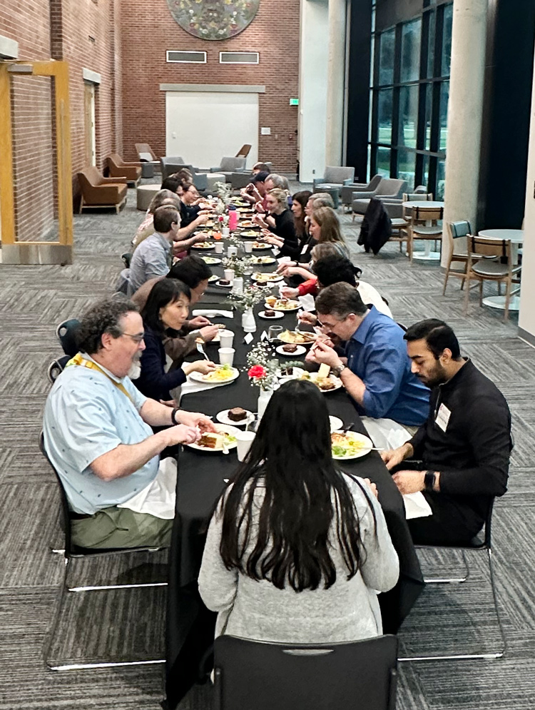 35 people gathered around the table having dinner.