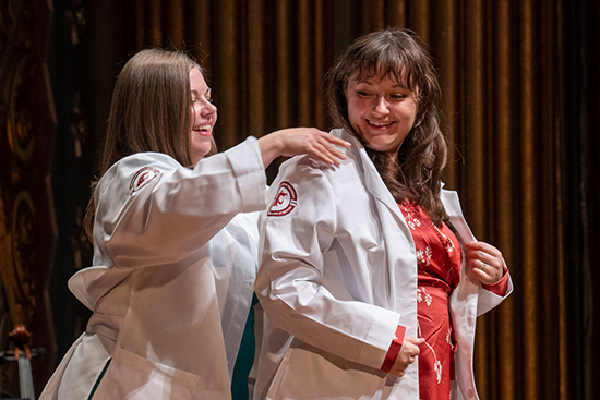 Student getting their white coat put on.