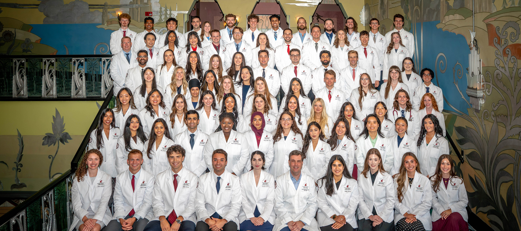 MD Class of 2030 in their white coats smiling.