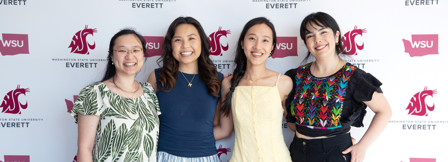 4 Internal Medicine residents smiling and standing in front of a WSU backdrop.