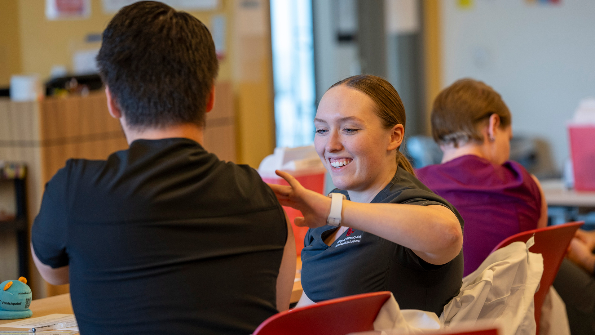 Pharmacy student prepping an arm for a shot.